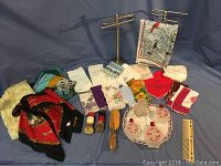 Full view of vintage handkerchiefs, scarves, towel stands, shaving cream brushes, wooden handled brush, and perfume bottles arranged on table