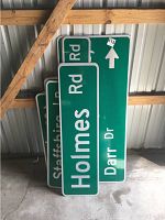 Stacked green street signs including Holmes Rd, Staffshire Ln and Darr Dr with directional arrow