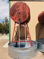 Overall view of tank mounted on stand above trough