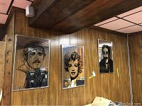 Photo showing all three mirrored wall arts hung on wood-paneled wall: Robert Redford, Marilyn Monroe, and Groucho Marx portraits.