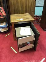 Wooden chest with open door revealing the Meilink safe inside, showing the safe's door open with combination dial and handle visible.