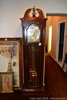 Front view of Ridgeway grandfather clock showing full height, wood finish, glass front, weights and pendulum
