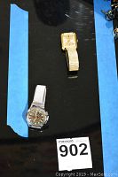Both watches shown side by side, PRYNGEPS gold-tone square face watch and CIMIER Panda Sport round dial watch with silver band