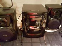 Front view of Panasonic portable CD boombox with dual speakers and Panasonic 5 CD shelf player, showing their condition and layout.
