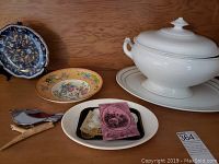 Photo showing the full lot with soup tureen, two decorative plates, small rectangular dish with paper ephemera and two bird figurines