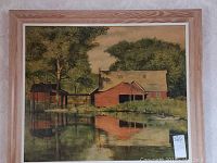 Framed countryside house picture showing red house near pond with trees and reflection.