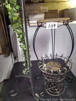 Overview of the three wrought iron plant stands with different styles and heights on display.