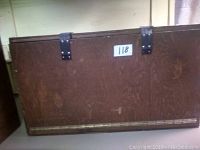 Closed view of the rectangular wooden cabinet with dark brown finish, metal hinges on top and a sticker labelled '118'.