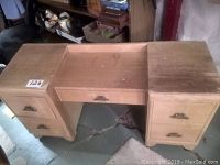 Front view of vintage wooden vanity desk showing two drawers on each side and central pull-out drawer, surface worn and unfinished.