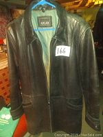 Front view of the black leather coat with two front pockets and zipper closure shown on a hanger.