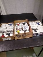 Lot of various colored fidget spinners in original white packaging arranged in cardboard boxes on a table.
