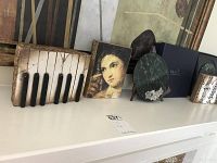 Overview of three Sid Dickens tiles and two marble plates on shelf