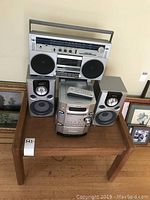 Front view of Sony speaker system and Toshiba radio cassette on wooden table