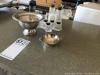 Photo of a kitchen counter displaying the large sterling silver bowl, smaller sterling silver bowl, and four crystal salt and pepper shakers with sterling tops.