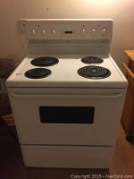 Front view of white Frigidaire electric stove showing four coil burners, control knobs, and oven door with window.