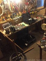 Workshop scene showing long workbench with various hand tools, saw blades, vices, sockets, and the closed carrying case for the video inspection system.