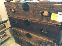Front view of taller Japanese Tansu chest showing 4 drawers with metal handles and circular decorative hardware.