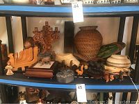Shelf displaying all items, showing baskets, figurines, candelabras, and cribbage board