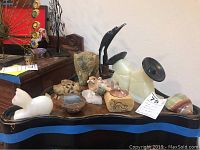 Wide view showing an assortment of stone and onyx figurines and incense burners including bookends, birds, and animals.