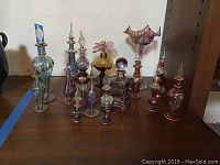 Group photo of 15 glass perfume bottles ranging from 4 to 7 inches tall, showing colors and shapes.