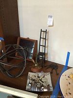 Wide view of lot items on wooden table showing iron sphere, chair, skeleton keys, weights, and tools