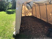Interior view showing soil floor and leaf debris inside tent