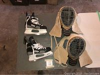 Full lot overview showing both Bauer skates and two protective masks with padded neck guards.
