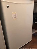 Full view of GE white bar fridge closed showing exterior.