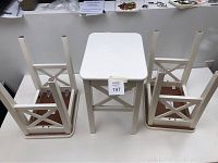 Set of three white IKEA INGOLF chairs, two flipped upside down, one upright showing top