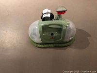 Bissell steam cleaner front view with cord and red brush attachment.