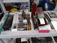 Overview of all tools displayed on white metal rack