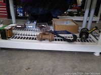 Overview of lot showing tapping attachment, strap, shackle, boxes of wheels