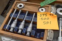 Wooden case with foam insert holding SPI internal micrometer heads and anvils labeled .275 to .500 SPI