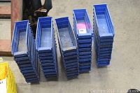 Overhead view of five stacks of blue plastic bins on warehouse floor
