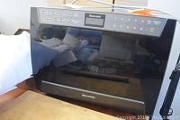 Closed view of Sharp Carousel microwave oven showing digital control panel and black exterior.