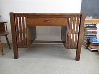 Front view of oak mission style desk showing single drawer and slatted side panels