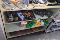 Three-tier shelf showing gauge pin trays, aerosol cans, sine vises and packaged solar panel