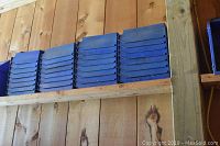 Wooden shelf holding stacks of blue open-front plastic bins