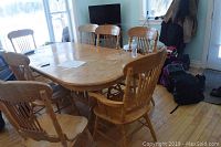 Full view of oak dining table with eight chairs around