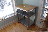 Front and side view showing laminated bamboo top and stainless steel frame on casters