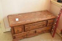 Front view of oak finished cedar chest showing decorative molding, brass hardware, and overall wear.