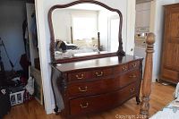 Front view of solid wood dresser with attached full-length framed mirror