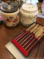Photo of two ceramic jars and a set of six steak knives in a red and white display box.