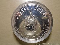 Obverse side of the silver dollar showing mounted rider and city skyline with inscriptions