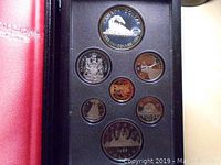 Top view showing the 1986 Canadian proof coins with the 50% silver dollar commemorating the first Trans-Canada train including various smaller coins in custom foam holders.