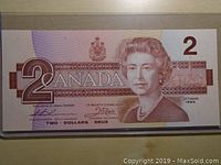 Front side of the 1986 Canadian two dollar bank note showing Queen Elizabeth II portrait and denomination.