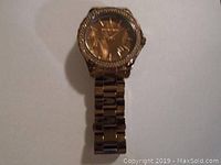 Full view of Michael Kors gold-tone watch with metal link bracelet and crystal bezel.