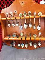 Full view of wooden rack with all 18 collector spoons displayed on two rows