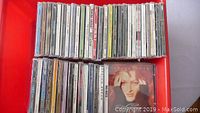Top-down image of box with 50 assorted audio CDs.