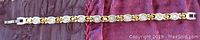 Top view of the two-tone link bracelet showing gold tone links with clear round stones and silver tone links in between, fully extended flat.
